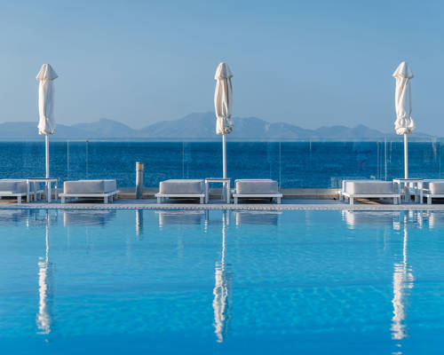 Pool and sunbeds with closed umbrellas