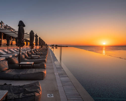Sunset side view of the pool and sunbeds